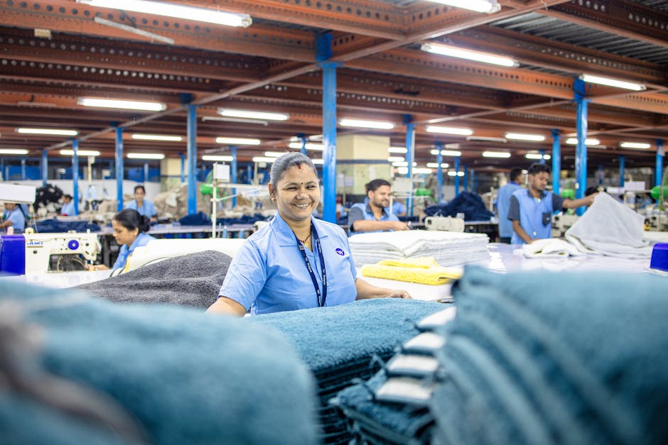 Happy textile worker in a vibrant factory showcasing teamwork and productivity.